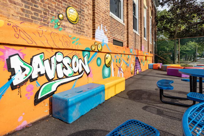 A colorful wall mural is painted on the side of Davison Ave School in Lynbrook, NY.