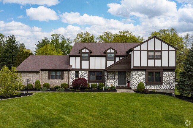 This brick Tudor Revival in West Monfort Heights features timeless woodwork.