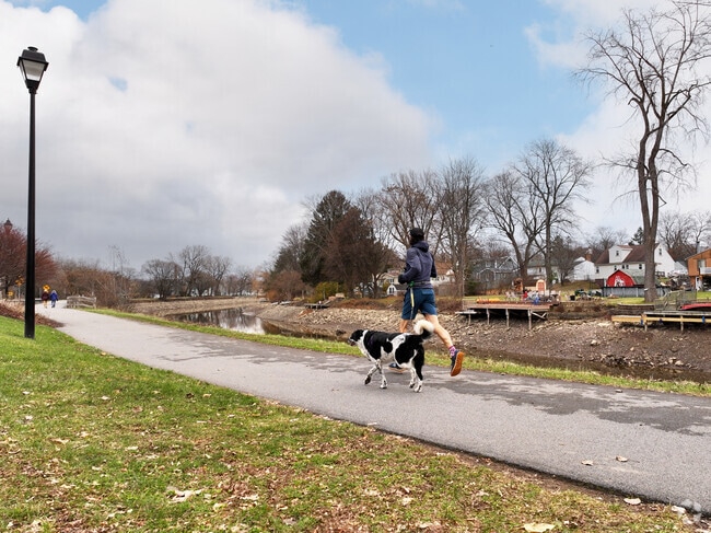 A man jogging with his canine companion in nearby Perinton Park.