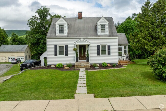 A Cape-style home in Chester sits quietly among trees, offering classic New England charm.