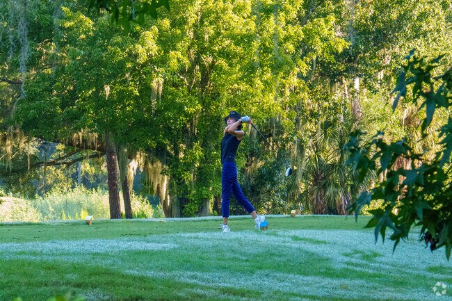 A young golfer prepares to tee off at Twin Rivers Golf Club near Live Oak Reserve.