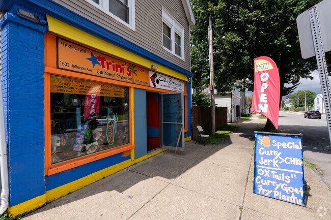 Trini's Caribbean Restaurant specializes in curry goat and jerk chicken .