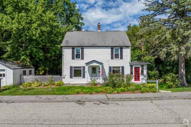 A colonial revival style home in the Maple Avenue District has black shutters and red door.