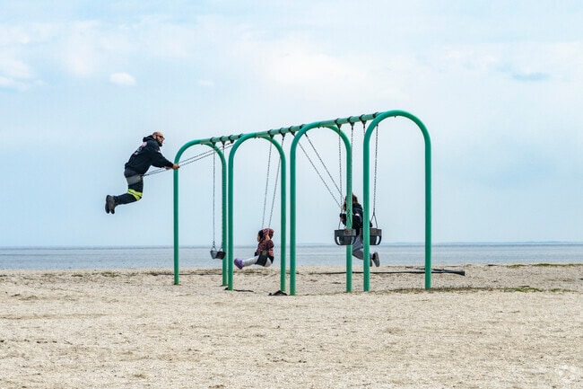 A family enjoys a swinging competition in Short Beach park in Stratford.