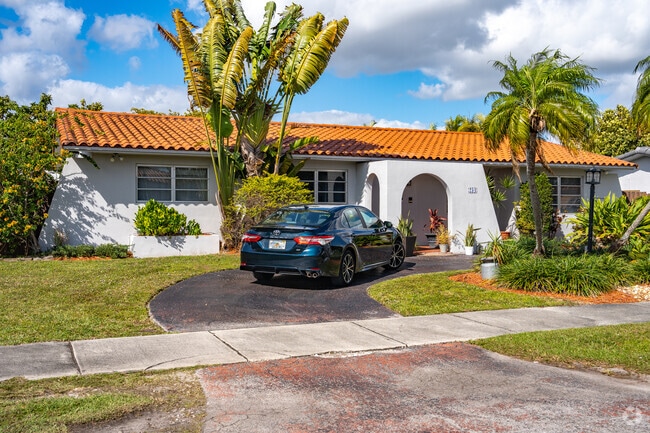 Some homes in Sweetwater are surrounded by lush palm trees and tall shrubbery.