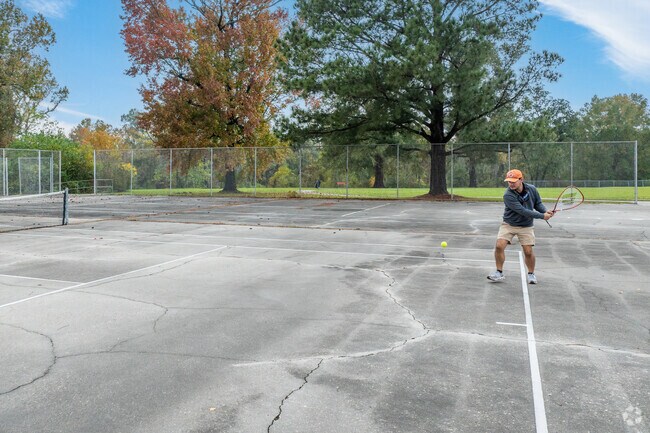 A resident of Gardere plays tennis at one of the several parks in the area.