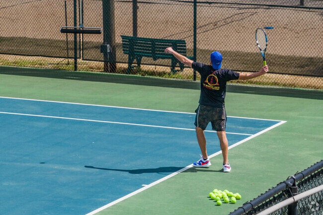Residents practice their tennis serve at the Leafmore-Creek Park Club.
