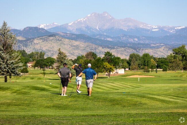 Men enjoy a game of golf with views of Longs Peak at City of Longmont Twin Peaks Golf Course.