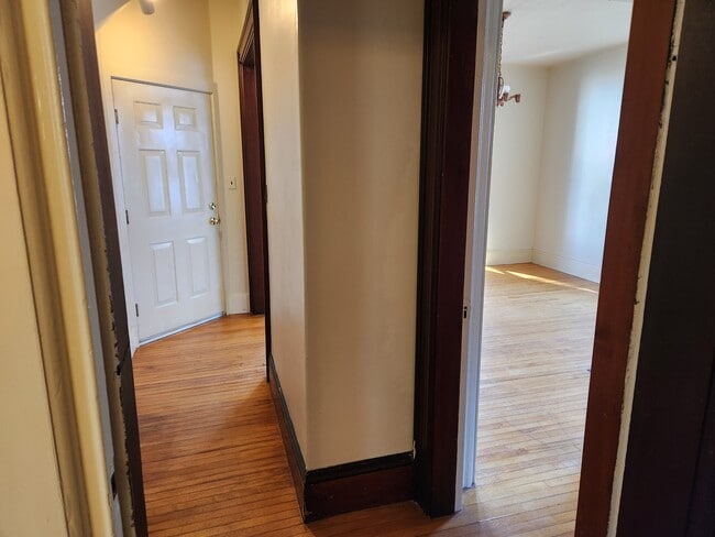 Looking back at front door and bedroom 1 from middle room