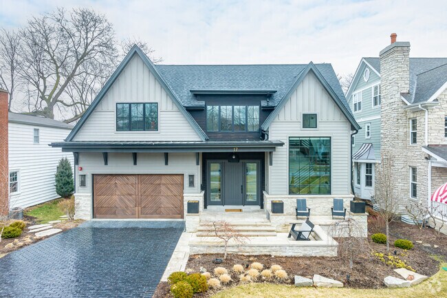 Contemporary craftsman-style home with large windows and a front porch in Clarendon Hills.