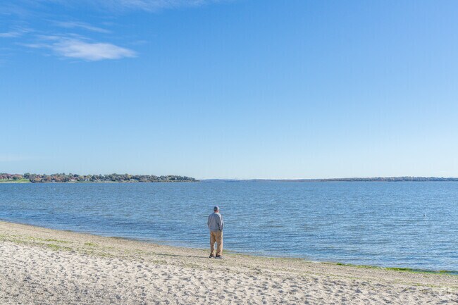 A person stands on Sandy Point Beach, entranced by the ocean's endless expanse.