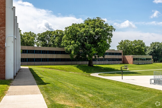 The building of Merrill Middle School is tucked amongst mature trees.