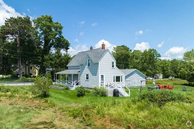 A farmhouse style home with a farmers porch in Kennebunk.