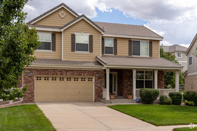 A Murphy Creek craftsman style home with a large yard and a covered porch.