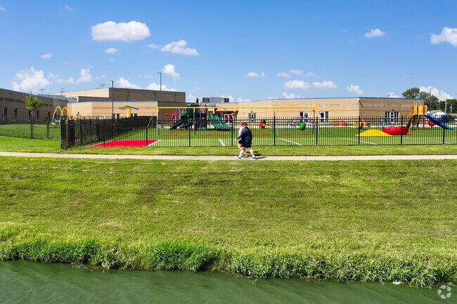 Two residents enjoy the walking trail near School Street Pond in Rose Hill.
