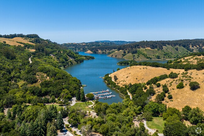 Lake Chabot Park is encompassed by scenic natural beauty including lush greenery and hills.