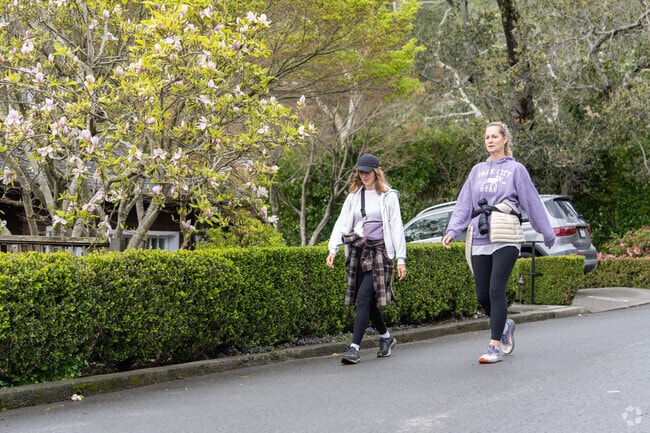 Friends and neighbors walk the streets surrounded by natural beauty in The Loop.