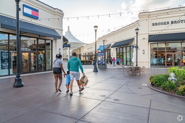 Shoppers stroll through Tanger Outlets near Lake Belvedere Estates.