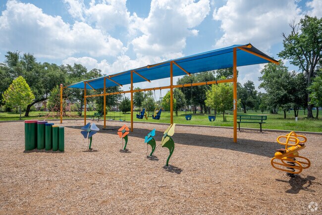 Children explore, creating memories on Reginald Moore Community Park's playful grounds.