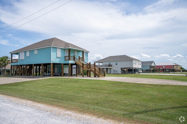 A row of acadian style beach homes sit on a canal in Hackberry, LA.