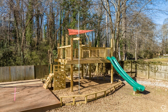 Multiple play structures dot the Hirsch Academy's treed play area.
