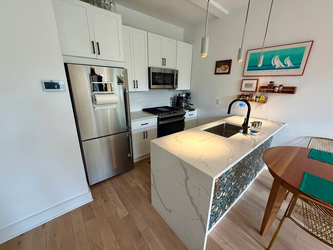 Kitchen with stainless steel appliances and quartz peninsula