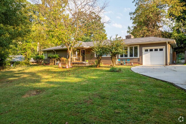 A ranch style home in Bradford-Ridgewood has a large green grassy yard with a long driveway.