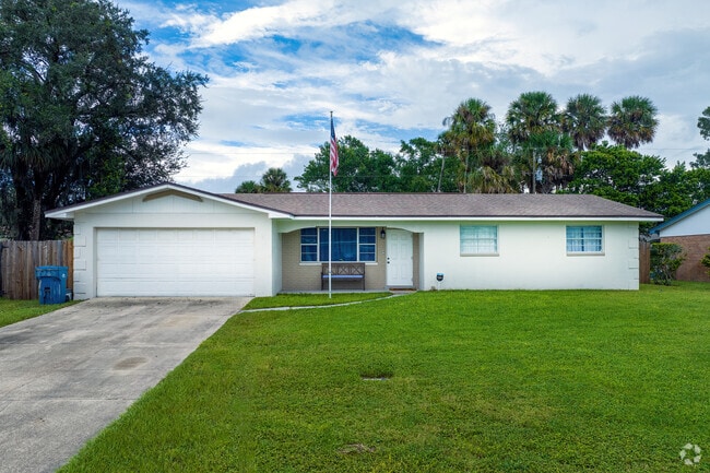 Mature palm trees offer shade and privacy to this ranch-style home in Neighborhood K.
