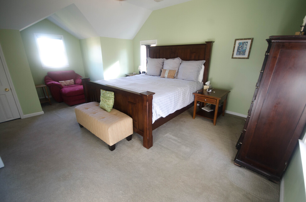Vaulted master bedroom with space for king-sized bed, armchair, and more furniture