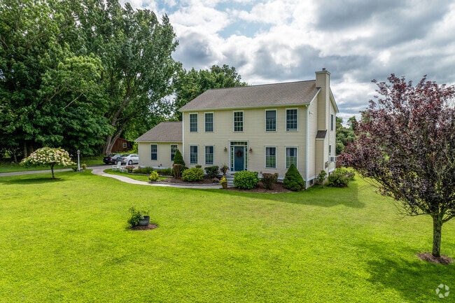 A light yellow colonial style home in Franklin has a large front yard.
