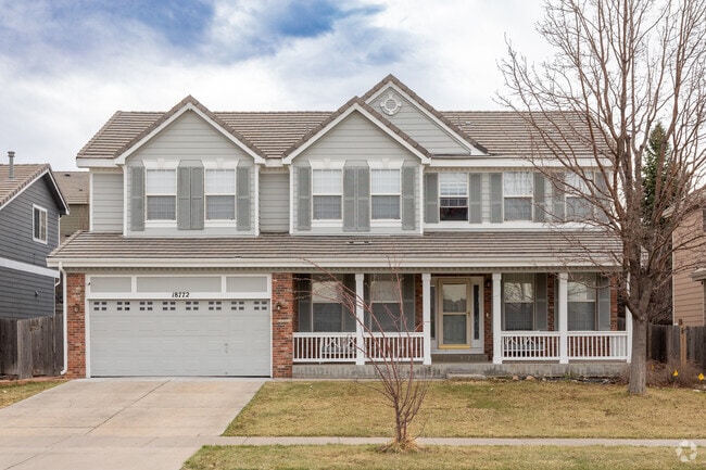 A farmhouse-style home with a large porch and two-car garage in Sterling Hills.
