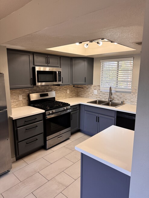 Beautiful kitchen with custom lighting and countertops, stainless steel appliances