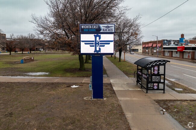 There is a sign for East High School near the main road.