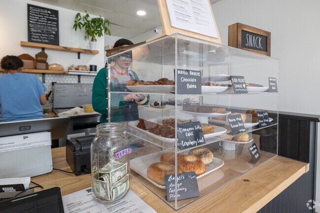 Happy staff restock the pastry case at Notes Coffee Co in Darlington, Pawtucket.