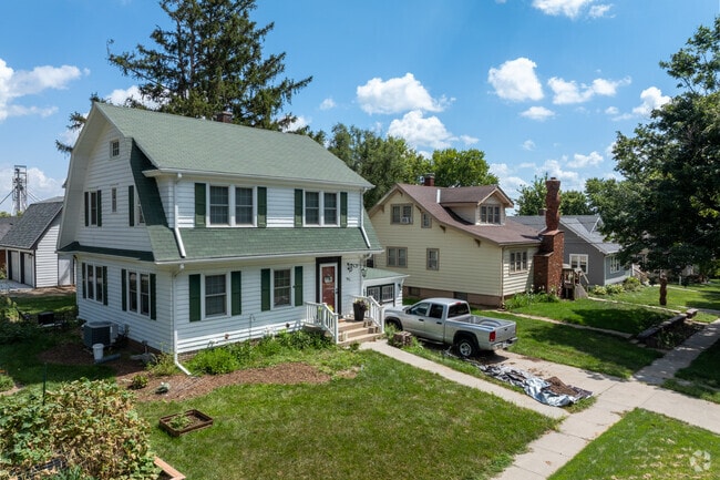 Two-story National-style homes in Wahoo often have driveways and mature trees.