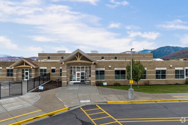 The entrance at Snowcrest Junior High School has green lawns and wide sidewalks.