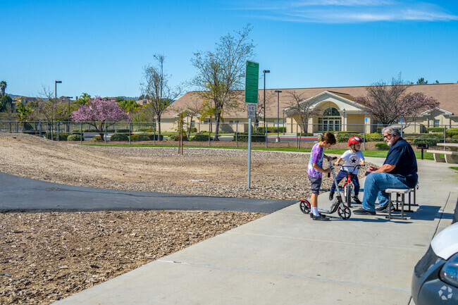 A proud grandpa watches his grandkids play joyfully at Long Canyon Creek Park in Meadowview, Temecula.