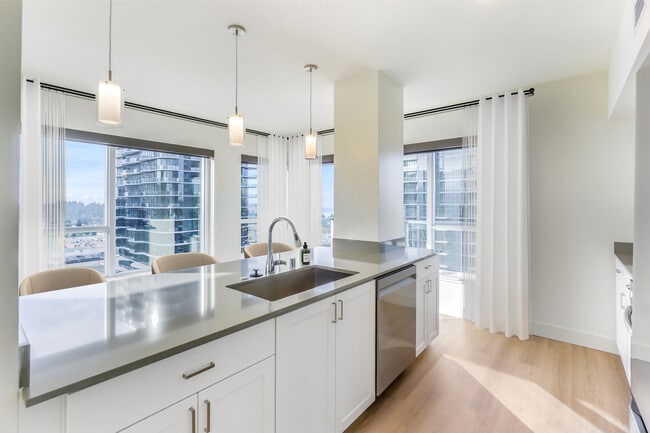 Renovated Package I kitchen with white cabinetry, grey quartz countertops, and hard surface flooring