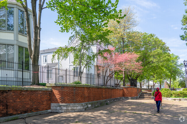 Tall red brick walls and shady trees make up the majority of Columbus Square's sidewalks.