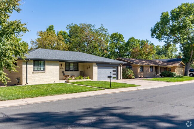 Brick ranch-style homes with sidewalks curve next to car-lined streets.