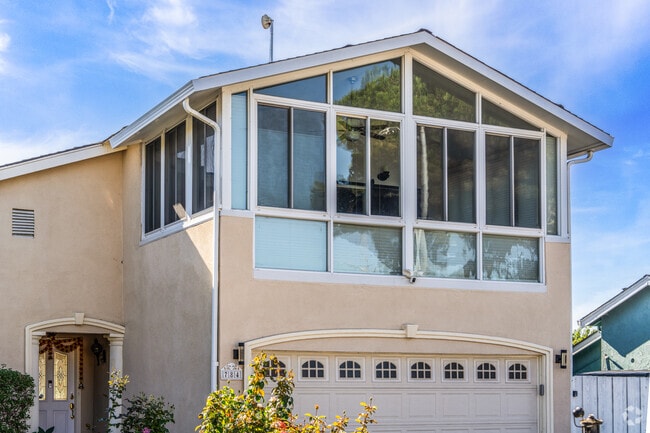 Windows frame scenic views of neighboring homes and the surrounding landscape.