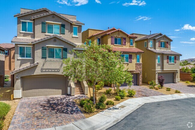 In Mountain's Edge, properties sit close together with uniform driveways and rocky lawns with small shrubs.