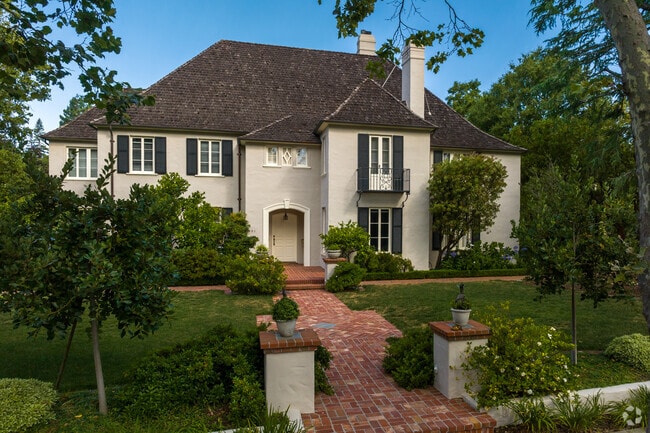 A red brick pathway leads to a luxury home that is both regal and charming.