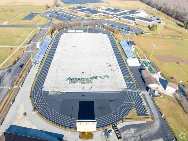 There is a football field near the back of the school building.