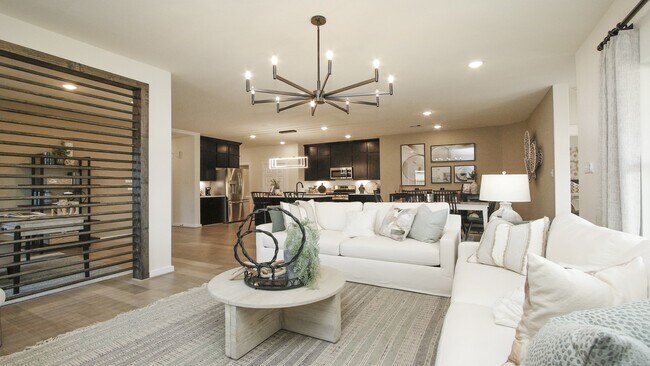 Discover open elegance with a sleek chandelier and refined kitchen in Colony at Pinehurst, Texas.