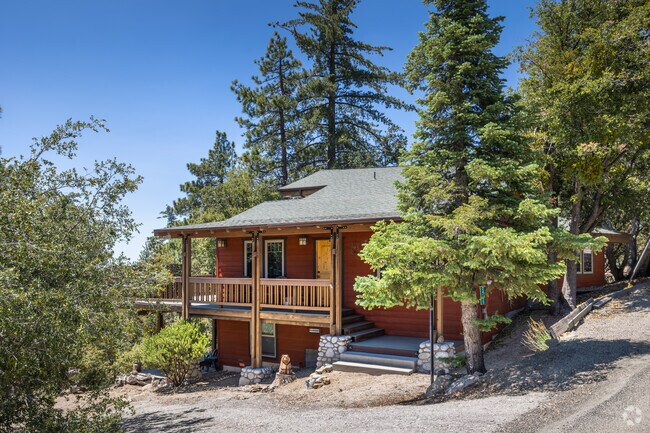 A Pine Cove cabin home painted in red features stone trim.