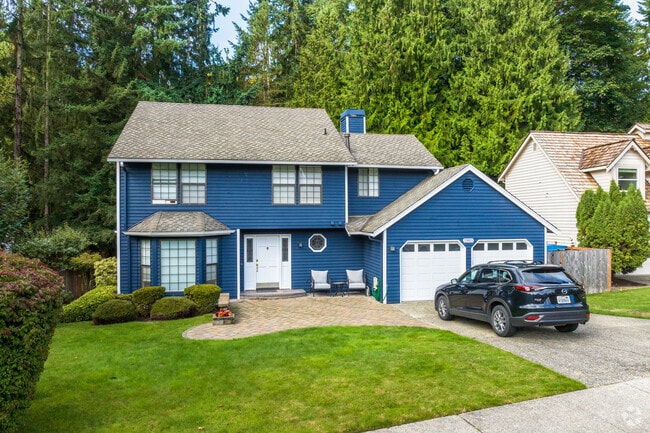 A blue two-story home sits quietly among trees in the heart of English Hill.