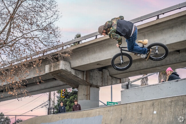 A guy catches air at Concord Skatepark while his buddies look on.