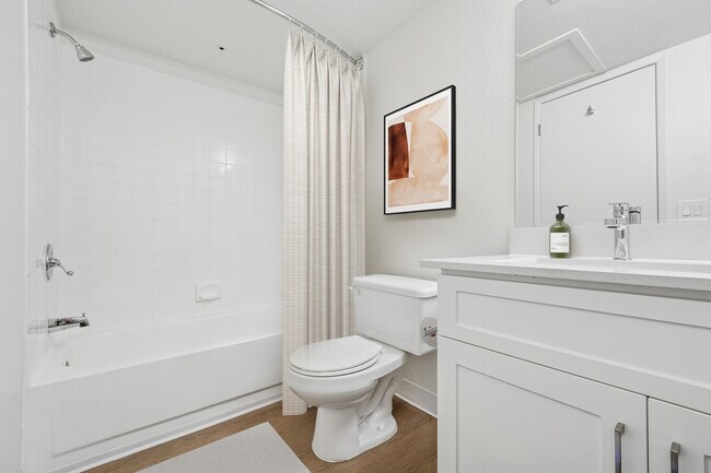 Upgraded Collection bath with white cabinetry, quartz countertop, and hard surface flooring