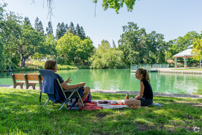 Residents enjoying a beautiful afternoon by the pond at Howe Community Park.